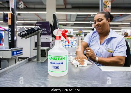 Kassierer wischen Oberflächen im Pick 'n Pay Supermarkt während des Virenausbruchs ab Stockfoto