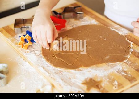 Kochen und Dekorieren von weihnachtlichem Lebkuchen. Hausgemachte Lebkekse, Formen und Backzutaten Stockfoto