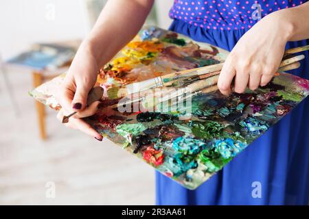 Kunstpinsel und Ölfarben auf Holzpalette. Makrokünstlerpalette, Texturen gemischte Ölfarben i Stockfoto