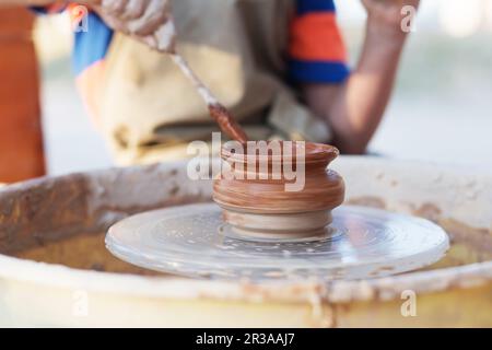 Hände von jungen Töpfer, die Schaffung eines irdenen Glas auf dem Kreis, Nahaufnahme Stockfoto