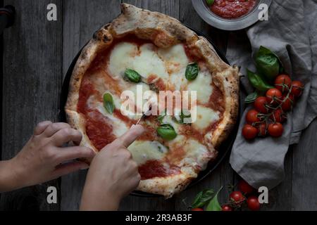 Ich Schneide Pizza Margherita Stockfoto