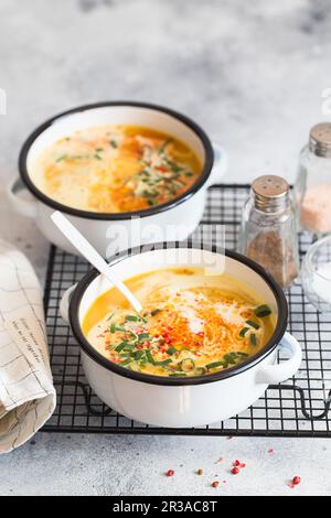 Kürbiscremesuppe. Geröstete Kürbis- und Karottensuppe mit Kurkuma, Sahne, Paprika, Schnittlauch und Stockfoto