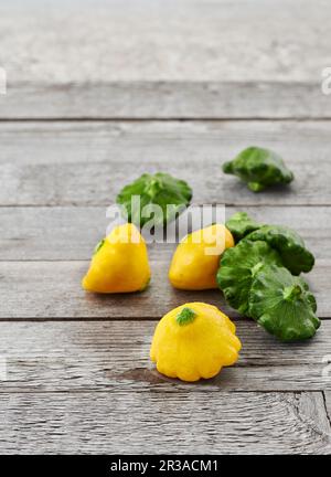 Mini-gelbe und grüne Pfannensuppe auf einem rustikalen Holztisch Stockfoto