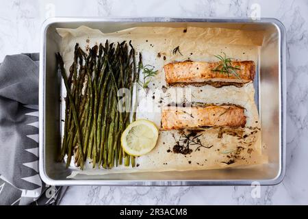 Im Ofen gebackener Lachs und Spargel, gewürzt mit Olivenöl und Rosmarin Stockfoto