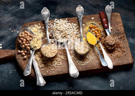 Gesunde glutenfreie Körner und Mehl auf rustikalem Holzbrett Stockfoto