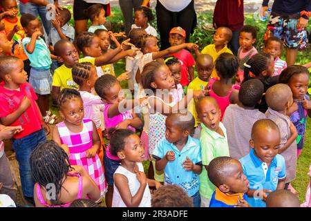 Junge afrikanische Vorschulkinder singen Lieder auf dem Spielplatz einer Kindergartenschule Stockfoto