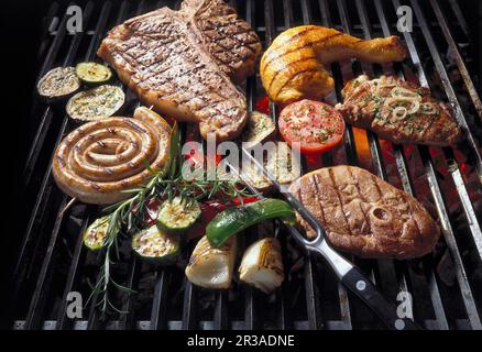 Fleisch, Geflügel und Gemüse auf einem Grillgitter Stockfoto