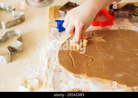 Kochen und Dekorieren von weihnachtlichem Lebkuchen. Hausgemachte Lebkekse, Formen und Backzutaten Stockfoto