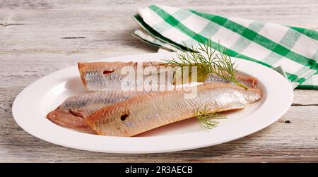 Geräucherte Heringsfilets mit Dill auf einer ovalen Platte Stockfoto