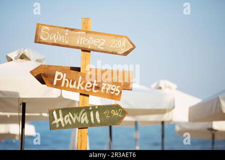 Holzpfosten mit Kopierbereich am Strand. Pfeile auf einem Führungsposten, die auf das Meer zeigen. Wegweiser Stockfoto