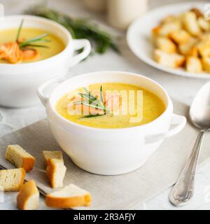 Fischsahnesuppe mit Lachs, Käse, Kartoffeln und Kräutern in weißen Suppenschalen. Stockfoto