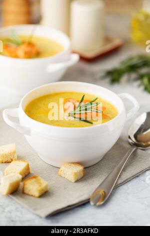 Fischsahnesuppe mit Lachs, Käse, Kartoffeln und Kräutern in weißen Suppenschalen. Stockfoto