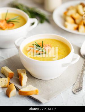 Fischsahnesuppe mit Lachs, Käse, Kartoffeln und Kräutern in weißen Suppenschalen. Stockfoto