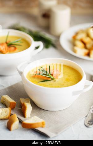 Fischsahnesuppe mit Lachs, Käse, Kartoffeln und Kräutern in weißen Suppenschalen. Stockfoto