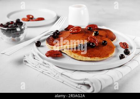 Gesundes Sommerfrühstück, hausgemachte klassische amerikanische Pfannkuchen mit frischen Beeren, Nüssen und Honig, Morni Stockfoto