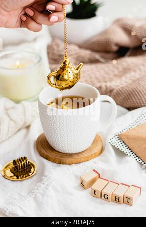 Tee mit einem goldenen Tee-Ei Stockfoto