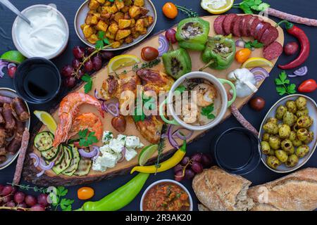 Antipasti-Platte mit verschiedenen Gemüsesorten, Garnelen, Dips, Obst, Brot und Huhn Stockfoto
