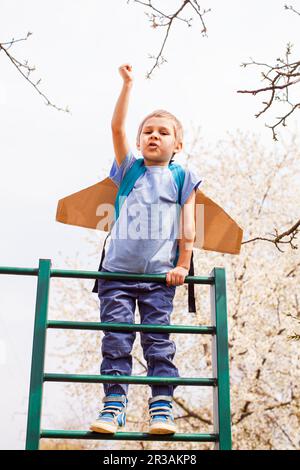 Aktiver kleiner Junge auf einem Klettergerüst, der davon träumt, einen Raumfahrer zu werden Stockfoto