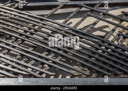 Ein schwarz lackiertes Holzgitter in schlechtem Zustand, weggeworfen in einem Baucontainer Stockfoto