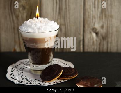 Handgemachte Kerze in Form von Cocktailglas mit Kaffee und cremigem weißem Schaum Stockfoto