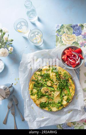 Frühlingsfrittata mit Frühkartoffeln, Bohnen, Erbsen, Frühlingszwiebeln und Brokkoli Stockfoto