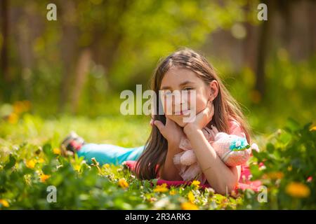 Das Mädchen ruht mit ihrem Lieblingsspielzeug im Hinterhof Stockfoto