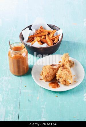 Knusprig gebackenes Hähnchen mit Rosmarin-Süßkartoffeln und Ketchup Stockfoto