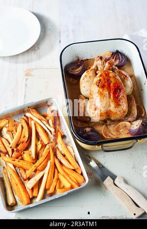 Zitronengebratenes Hähnchen mit gerösteten Wurzeln aus Orangenapfel Stockfoto