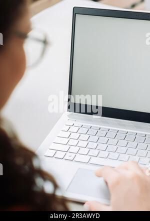 Schulteransicht einer Schülerin, die e-learning-inhalte auf einem weißen, aufgeblasenen Bildschirm mit Online-Lernen auf einem Laptop ansieht, Konzept für Remote-Arbeit. Web Stockfoto