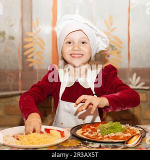 Kinder machen Pizza. Master Class für Kinder zum Kochen von italienischer Pizza. Kleine Kinder lernen, wie man kocht Stockfoto