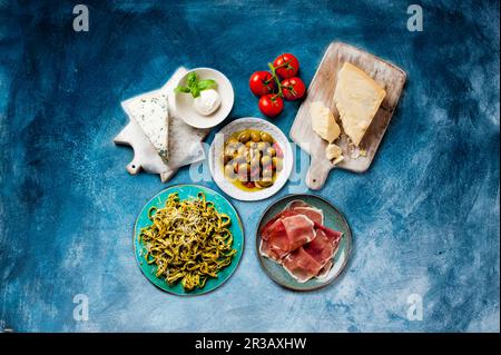 Antipasti: Verschiedene Käsesorten, eingelegte Oliven, Schinken und Nudeln Stockfoto