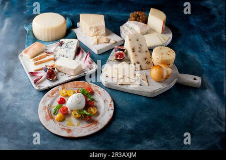 Antipasti: Verschiedene Käsesorten mit Obst und Tomaten Stockfoto