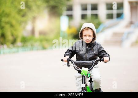 Portrait eines niedlichen kleinen Stadtjungen mit schwarzer Lederjacke. City-Style. Urbane Kinder. Der Junge Stockfoto