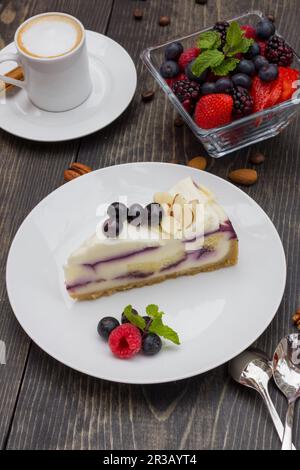 Eiskaffee, weißer Schokoladenkuchen mit Blaubeeren und schwarzen Kirschen Stockfoto