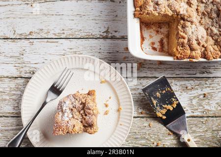 Ein Stück Krümelkuchen, serviert auf einem weißen Teller mit einem Gabelschuss von oben Stockfoto