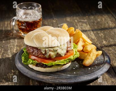 Rindfleisch, Zwiebeln, Stilton, bap, karamellisierte Zwiebeln-Chutney, Tomaten, Salat, Chips, Salz, Bier Stockfoto