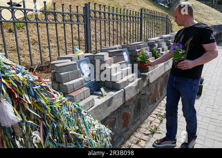 KIEW, UKRAINE - 23. MAI 2023 - Ein Mann hinterlässt Blumen an der Gedenkstätte in der Allee der himmlischen Hundert Helden am Tag der Helden, Kiew, Hauptstadt von Stockfoto