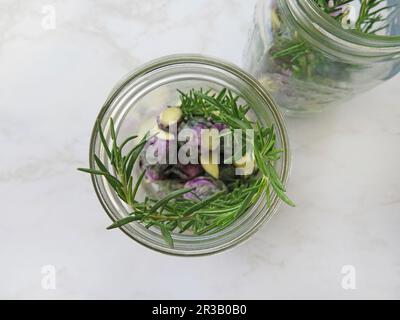 Violetter Rosenkohl in zwei Gläsern, die mit Rosmarin eingewürzt werden Stockfoto