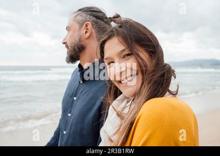Glückliche Frau mit einem erwachsenen Mann, der vor dem Meer steht Stockfoto