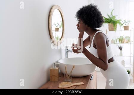 Junge Frau im Spiegel im Badezimmer suchen Stockfoto