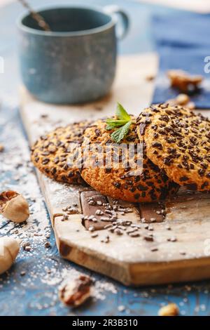 Kekse mit Schokoladenstückchen auf dem Holzbrett. Mystic Light Food Fotografie. Stockfoto