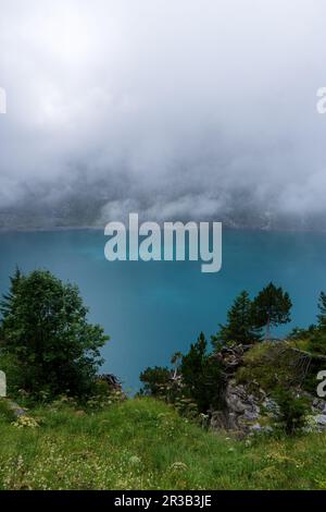 Herrliches touristisches Oeschinnensee mit Wasserfällen und Schweizer Alpen, Kandersteg, Berner Oberland, Schweiz. Stockfoto