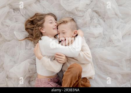 Bruder und Schwester liegen auf Tulle-Netz Stockfoto