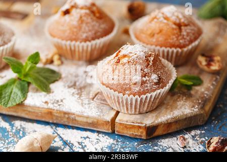 Süße Muffins. Hausgemachte Bäckerei auf Holz Hintergrund. Beerenmuffins mit Puderzucker Stockfoto