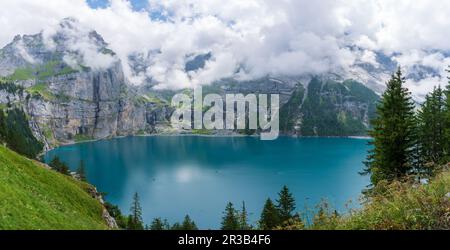 Herrliches touristisches Oeschinnensee mit Wasserfällen und Schweizer Alpen, Kandersteg, Berner Oberland, Schweiz. Stockfoto