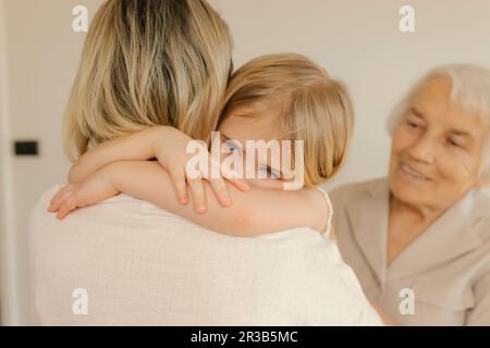 Tochter umarmt Mutter zu Hause Stockfoto