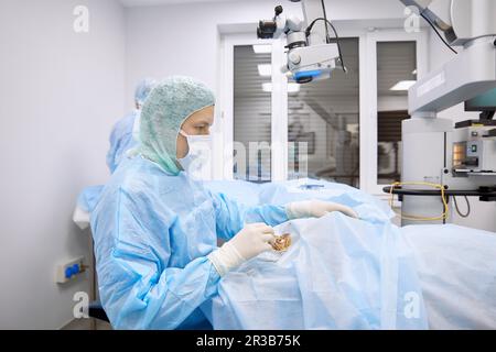 Chirurg untersucht das Auge des Patienten im Operationssaal Stockfoto