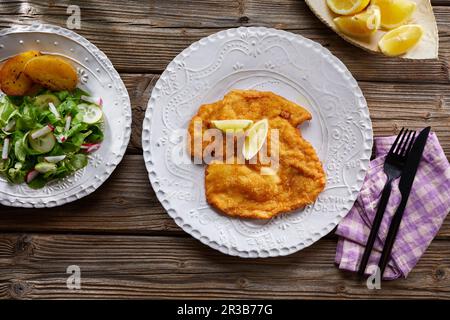 Wiener Schnitzel (paniertes Kalbfleisch) mit Salat Stockfoto