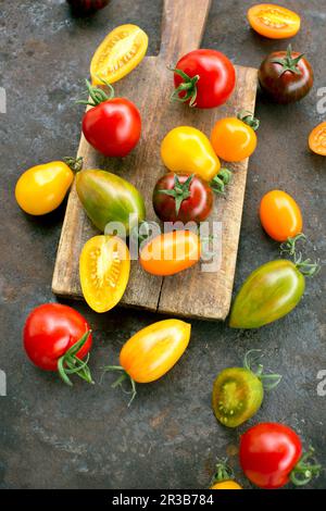 Bunte Tomaten auf rustikaler Oberfläche Stockfoto