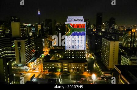Blick von oben auf das beleuchtete Gebäude und die Straßenszenen des Vororts Braamfontein im Geschäftsviertel von Johannesburg bei Nacht Stockfoto